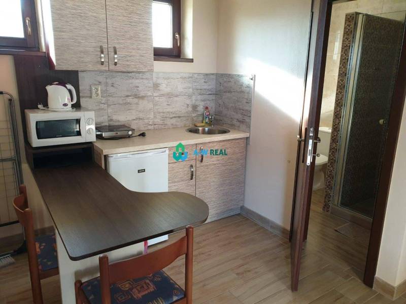 Apartmánový dom na predaj blízko termálneho kúpaliska - Kompaktná kuchyňa s chladničkou a mikrovlnkou na ulici neuvedené, vedľa obchodné priestory.