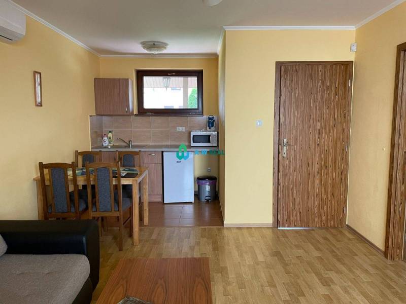 Apartmánový dom na predaj blízko termálneho kúpaliska - Kuchynka a jedálenský kút v byte so štyrmi stoličkami, svetložlté steny.