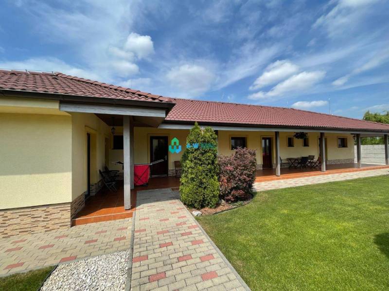 Apartmánový dom na predaj blízko termálneho kúpaliska - Na ulici neuvedené, vidno obchodné priestory s trávnikom a terasou.