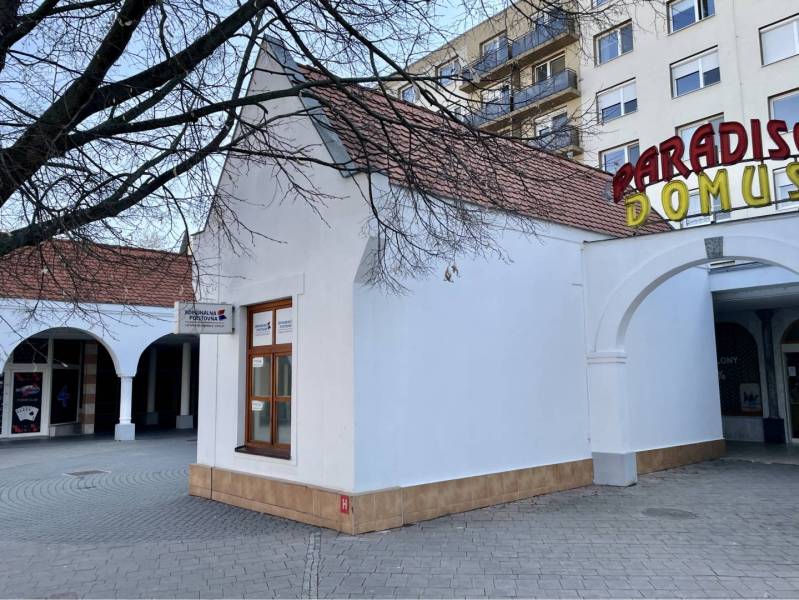 DUNASJKÁ STREDA – OBCHODNÝ PRIESTOR PRIAMO V CENTRE MESTA - Budova s oblúkmi a nápisom na Námestí Ármina Vámbéryho v Dunajskej Strede.