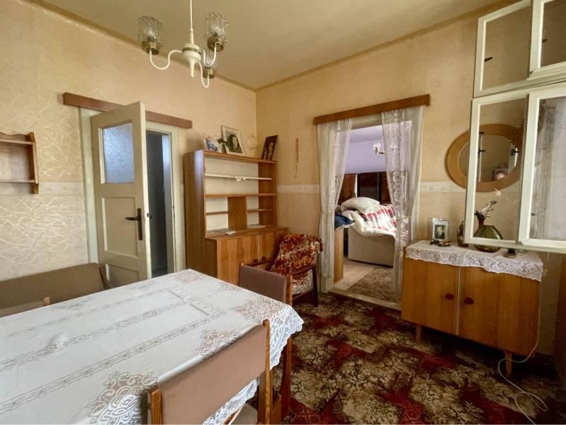 VRAKÚŇ – STARÝ RODINNÝ DOM NA PREDAJ S VEĽKÝM POZEMKOM - 24 ÁROV - Tradičná jedáleň v rodinnom dome s čipkovaným obrusom a dreveným nábytkom.