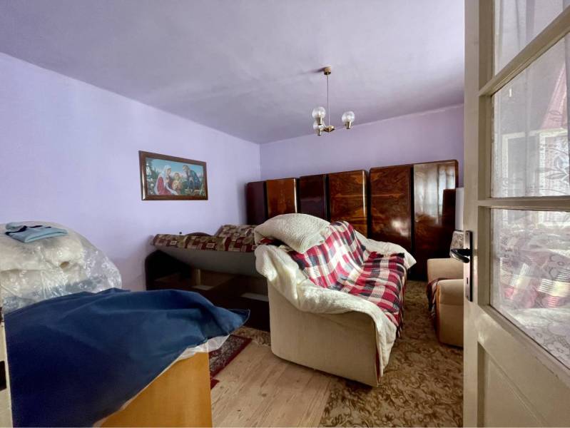 VRAKÚŇ – STARÝ RODINNÝ DOM NA PREDAJ S VEĽKÝM POZEMKOM - 24 ÁROV - Izba s pohovkou, koberec, skrine a obraz, Rodinný dom.