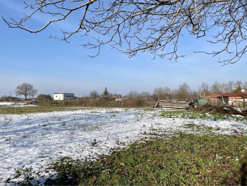 VRAKÚŇ – STARÝ RODINNÝ DOM NA PREDAJ S VEĽKÝM POZEMKOM - 24 ÁROV - Zimná krajina vo Vrakúni so snehom na neznámej ulici a zopár vidieckych stavieb.