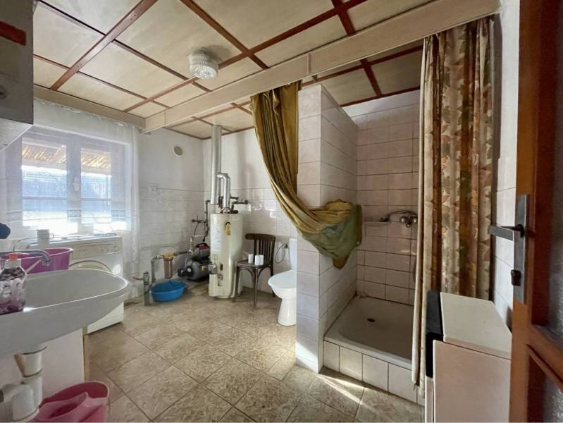 VRAKÚŇ – STARÝ RODINNÝ DOM NA PREDAJ S VEĽKÝM POZEMKOM - 24 ÁROV - Kúpeľňa v rodinnom dome s umývadlom, vaňou, bojlerom a kachličkovou podlahou.