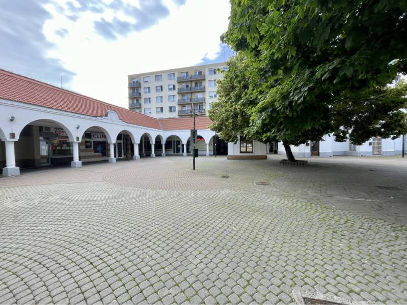 Obchodný priestor na prenájom v srdci Dunajskej Stredy - Obchodné priestory na Námestí Ármina Vámbéryho v Dunajskej Strede, obkolesené stromami a oblúkmi.