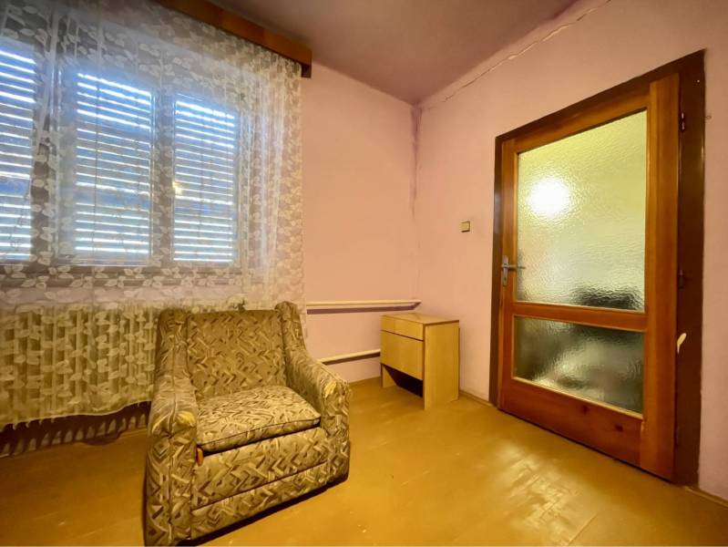 TOPOĽNÍKY – 4-IZBOVÝ RODINNÝ DOM NA PREDAJ NA 14 ÁROVOM POZEMKU - Izba v rodinnom dome s kreslom, podlahou s dreveným dekorom a francúzskym oknom.