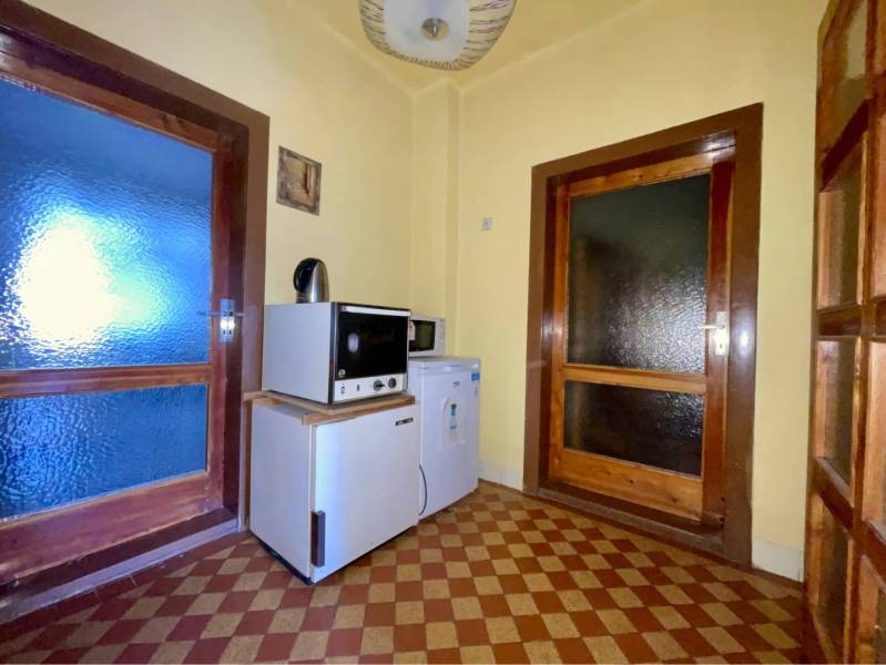 TOPOĽNÍKY – 4-IZBOVÝ RODINNÝ DOM NA PREDAJ NA 14 ÁROVOM POZEMKU - Kuchynka v rodinnom dome s dlažbou so vzorom a drevenými dverami.