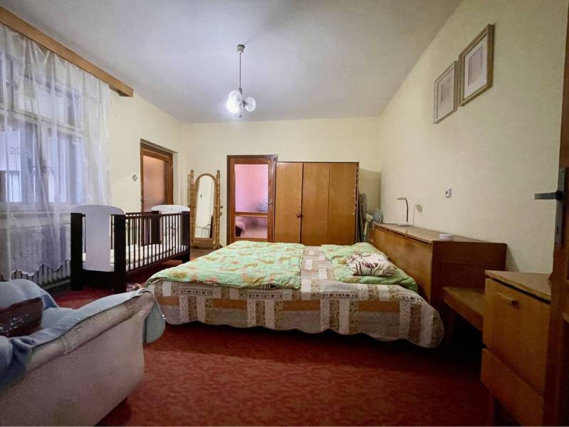TOPOĽNÍKY – 4-IZBOVÝ RODINNÝ DOM NA PREDAJ NA 14 ÁROVOM POZEMKU - Spálňa v rodinnom dome s posteľou, detskou postieľkou, skrinkami a zrkadlom.