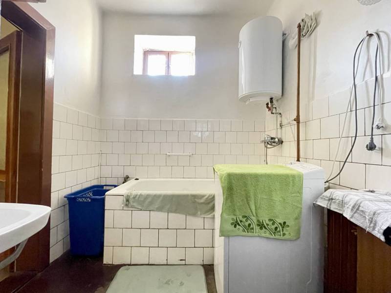 TOPOĽNÍKY – 4-IZBOVÝ RODINNÝ DOM NA PREDAJ NA 14 ÁROVOM POZEMKU - Kúpeľňa v rodinnom dome s práčkou, umývadlom a bojlerom, obložená bielymi dlaždicami.