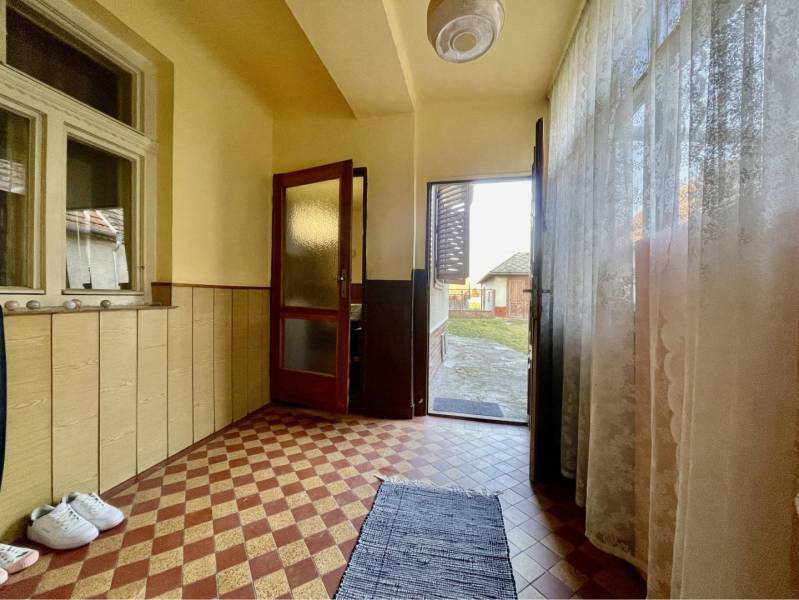 TOPOĽNÍKY – 4-IZBOVÝ RODINNÝ DOM NA PREDAJ NA 14 ÁROVOM POZEMKU - Vstupná chodba v rodinnom dome s dlažbou a výhľadom do záhrady.