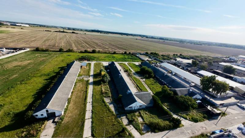 Kostolné Kračany - skladové - prevádzkové priestory na predaj za cenu  - Letecký pohľad na výrobné priestory na Amadeho Kračany v Kostolnom Kračanoch obklopené poľami.