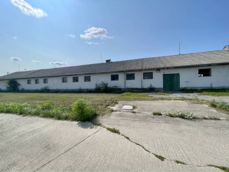 Kostolné Kračany - skladové - prevádzkové priestory na predaj za cenu  - Výrobné priestory na Amadeho Kračany v Kostolných Kračanoch, nízka budova s betónovou plochou.