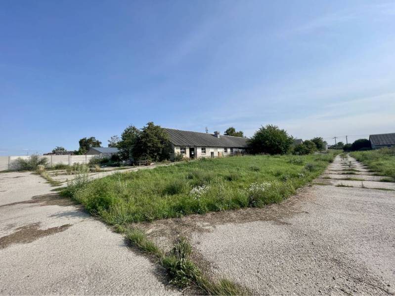 Kostolné Kračany - skladové - prevádzkové priestory na predaj za cenu  - Výrobné priestory na ulici Amadeho Kračany, Kostolné Kračany, so zeleňou a budovou v pozadí.