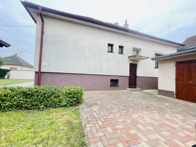 A-W REAL | KOMPLETNE PREROBENÝ RODINNÝ DOM NA PREDAJ V KĽUDNEJ ČASTI M - Rodinný dom na Žitnoostrovskej ulici v Dunajskej Strede, obklopený záhradou a vyloženým chodníkom.