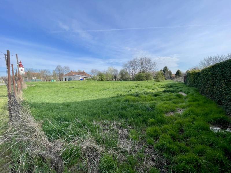 OKOČ – POZEMOK NA PREDAJ V CENTRE DEDINY - Pozemok na bývanie v Okoči s výhľadom na kostol zo zelenej lúky.