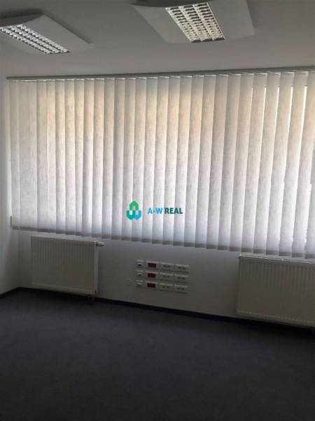 Kancelárie v centre mesta. - Kancelária s vertikálnymi žalúziami, radiátory na ulici Hlavná, zásuvky na stene.