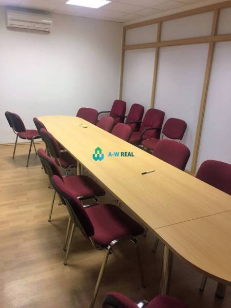 Kancelárie v centre mesta. - Konferenčná miestnosť na ulici Hlavná s bordovými stoličkami a drevenými stolmi v kancelárii.