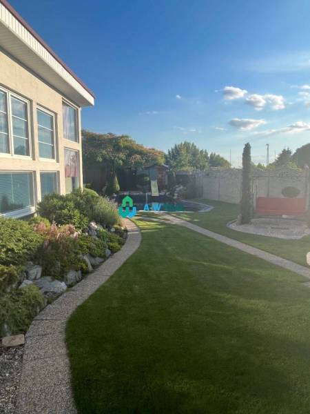 Znížená cena!  Rodinný dom s vnútorným aj vonkajším bazénom na krásne  - Pokojná záhrada pri rodinnom dome, s udržiavaným trávnikom, kvetinovými záhonmi a chodníkom.