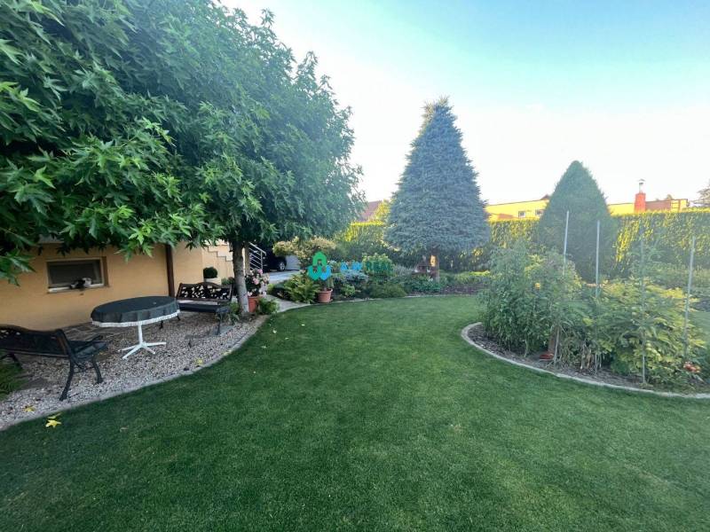 Znížená cena!  Rodinný dom s vnútorným aj vonkajším bazénom na krásne  - Záhrada s upraveným trávnikom, stromami a rastlinami, vedľa rodinný dom.