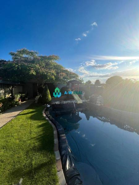 Znížená cena!  Rodinný dom s vnútorným aj vonkajším bazénom na krásne  - Rodinný dom s krásnou záhradou, bazénom a modrou oblohou na ulici neuvedene.