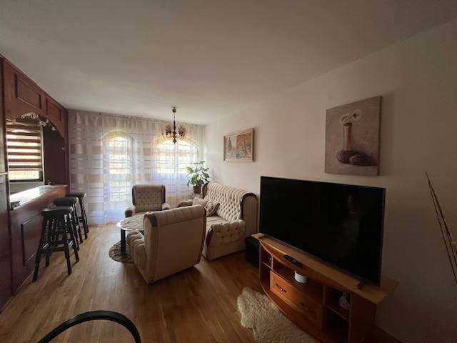 Rodinný  dom na predaj v Gabčíkove - Obývacia izba s drevenou podlahou, sedačkou, televízorom a ozdobným osvetlením v rodinnom dome.