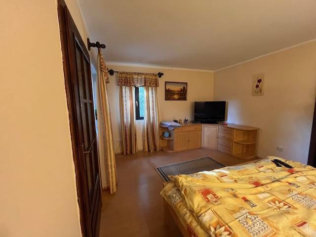 Rodinný  dom na predaj v Gabčíkove - Útulná spálňa s dreveným nábytkom, balkónom a televízorom v rodinnom dome.