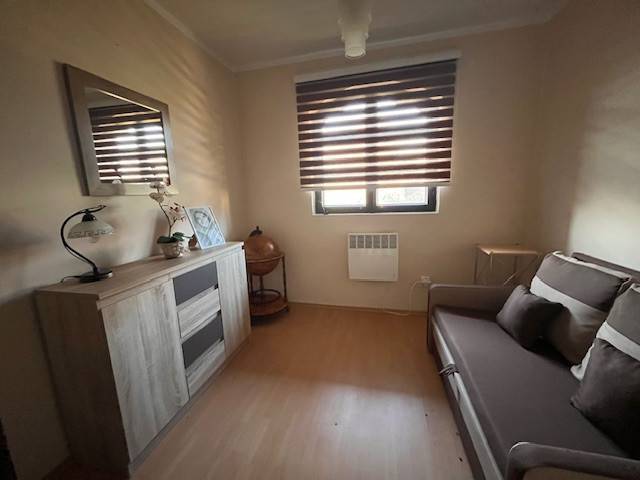 Rodinný  dom na predaj v Gabčíkove - Izba s pohovkou, skrinkou, dekoráciami a oknom s rolety, vhodná pre útulný rodinný dom.