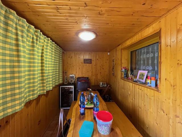 Rodinný  dom na predaj v Gabčíkove - Drevený rodinný dom s dlhou lavicou a teplými záclonami, vybavený doplnkami na stole.