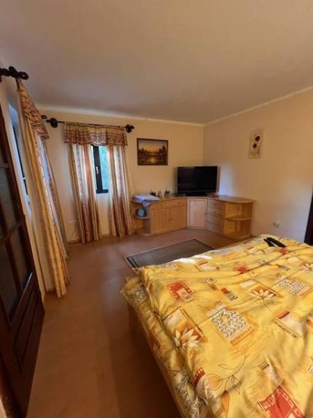Rodinný  dom na predaj v Gabčíkove - Spálňa s posteľou, skriňami a televízorom, útulný priestor v rodinnom dome.