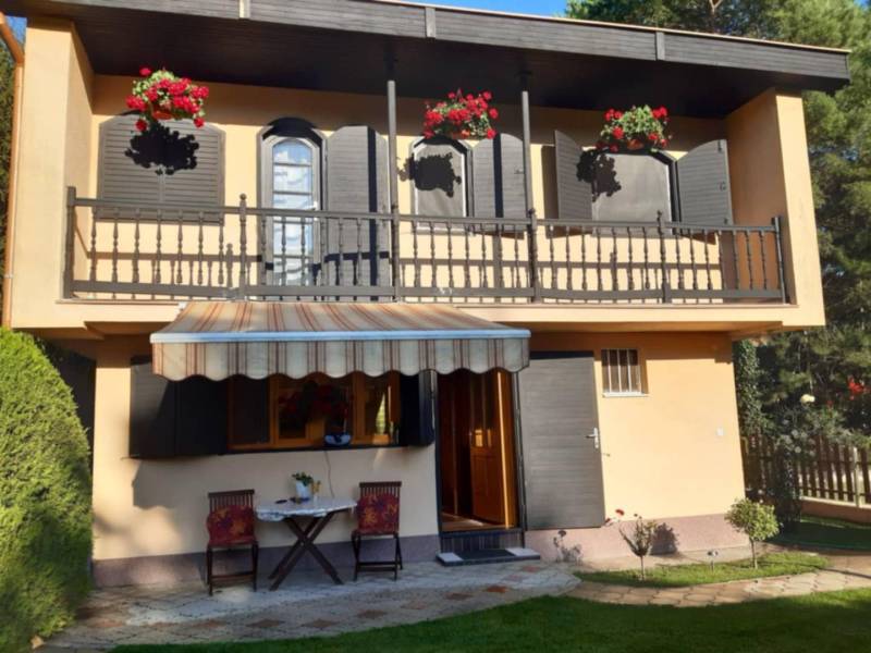 Rodinný  dom na predaj v Gabčíkove - Rodinný dom v Gabčíkove s balkónom, kvetmi, altánkom a dvoma stoličkami na trávniku.