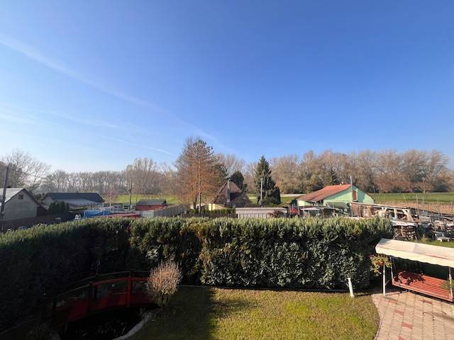 Rodinný  dom na predaj v Gabčíkove - Záhrada v Gabčíkove s výhľadom na okolité rodinné domy a modrú oblohu.