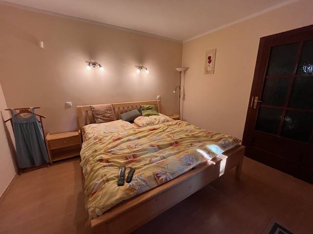 Rodinný  dom na predaj v Gabčíkove - Spálňa s manželskou posteľou, lampami a dreveným nábytkom v rodinnom dome.