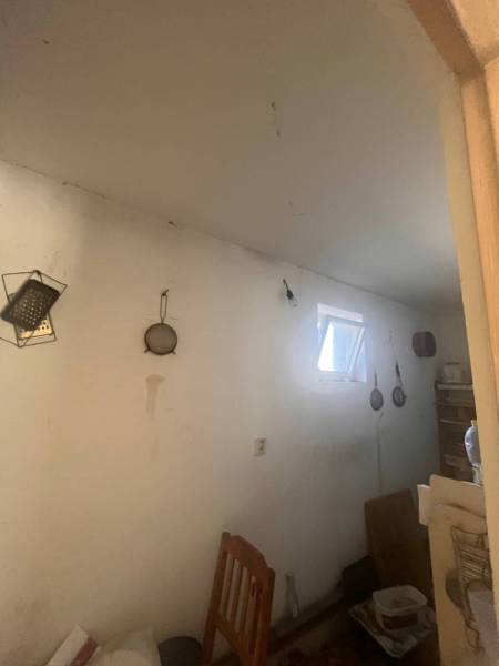 ☎️    0918 846 340    Rodinný dom okamžite obývateľný. - Izba v rodinnom dome so zavesenými nástrojmi, stoličkou a malým oknom.