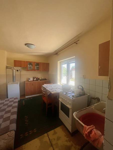 ☎️    0918 846 340    Rodinný dom okamžite obývateľný. - Kuchyňa v rodinnom dome s plynovým sporákom, chladničkou a jedálenským stolom.