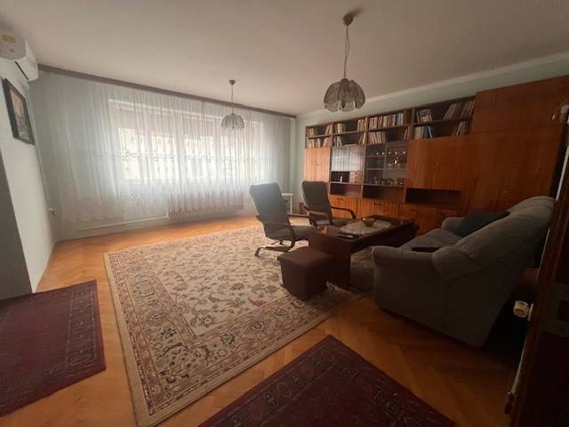 ☎️ 0918 846 340       Výrazne znížená cena len 210 000 eu. Dvojgenerač - Obývačka v rodinnom dome s knižnicou, pohovkou a kobercami na podlahe s dreveným dekorom.