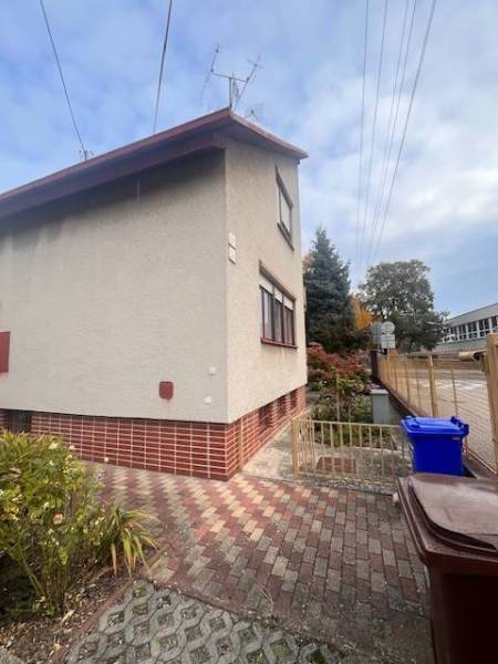 ☎️ 0918 846 340       Výrazne znížená cena len 210 000 eu. Dvojgenerač - Rodinný dom v Dunajskej Strede s omietkou, tehlovým soklom, vegetáciou a odpadovými nádobami.