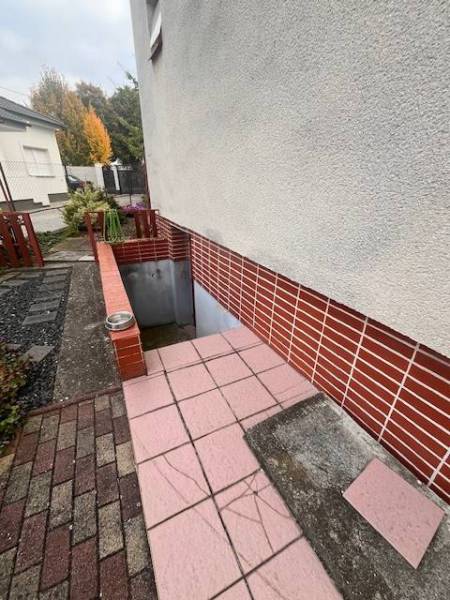 ☎️ 0918 846 340       Výrazne znížená cena len 210 000 eu. Dvojgenerač - Vchod do suterénu rodinného domu v Dunajskej Strede s červenými tehlovými obkladmi.