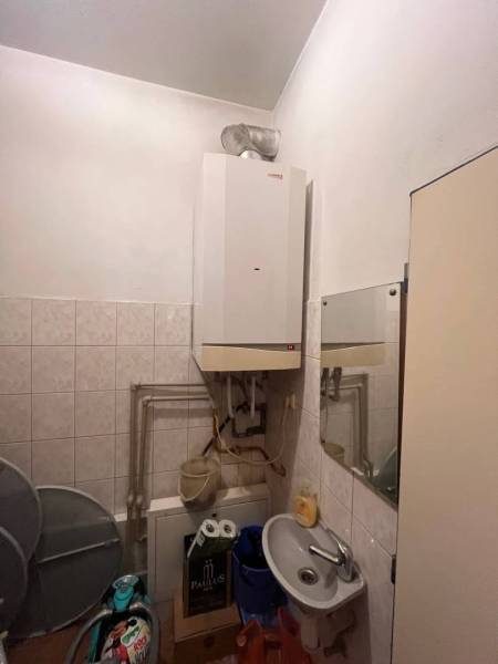 Znížená cena!!!!   Obchodný priestor na predaj. - Kúpeľňa v obchodných priestoroch s umývadlom, zrkadlom a bojlerom na bielej stene.