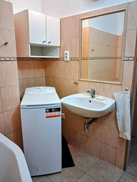 ☎️   0918 846 340           Byt v centre mesta na Jesenského ulici. - Kúpeľňa v 1-izbovom byte s práčkou, umývadlom a nástennou skrinkou.