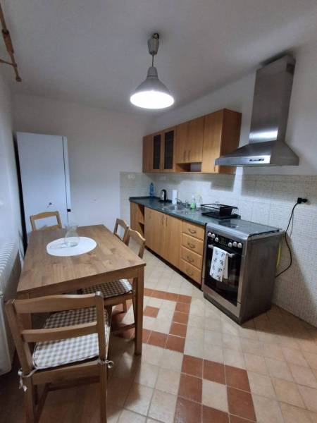 ☎️   0918 846 340           Byt v centre mesta na Jesenského ulici. - Kuchyňa v 1-izbovom byte s dreveným nábytkom, sporákom a podlahou so vzorom.