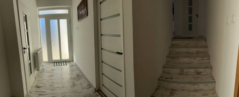 Ůžasný rodinný dom v obci Trstice. - Vstupná hala rodinného domu s podlahou s dreveným dekorom a schodiskom.
