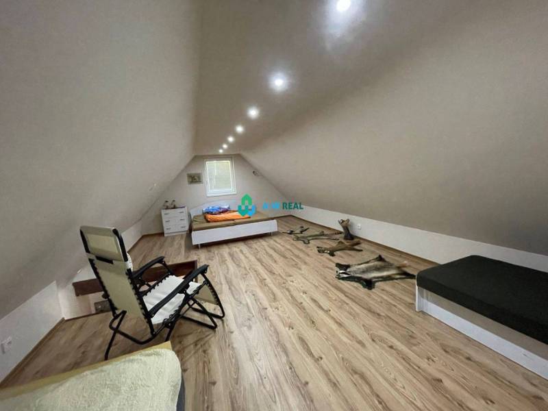 Odstúpenie nájomnej zmluvy - rekreačná chata v obci Bodíky!!! Cena  84 - Podkrovná izba s posteľou, kreslom a drevenou podlahou pri chate na ulici Bodíky.