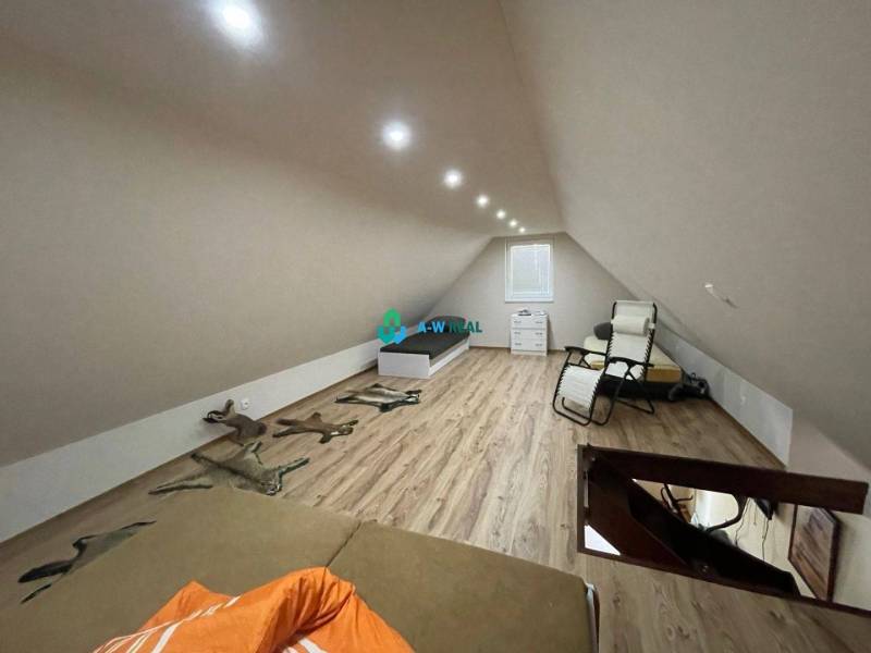 Odstúpenie nájomnej zmluvy - rekreačná chata v obci Bodíky!!! Cena  84 - Podkrovná izba s kreslom, posteľou a drevenou podlahou, na ulici Bodíky pri chate.