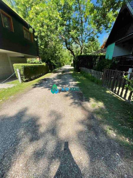 Odstúpenie nájomnej zmluvy - rekreačná chata v obci Bodíky!!! Cena  84 - Stromová ulica s chatami a zelenými plotmi, slnečný deň na ulici Bodíky.