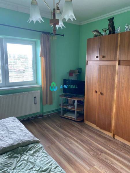Exkluzívna ponuka - čiastočne  prerobený 4-izbový rodinný dom na preda - Izba s drevenou podlahou, zelenými stenami, skriňami, postele s obliečkou, okno s roletami.
