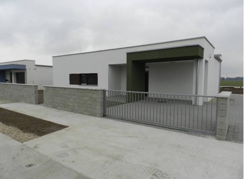 NOVOSTAVBA!!! Moderný nízkoenergetický 4 izbový rodinný dom vysokej kv - Rodinný dom na ulici Dolný Bar so svetlou fasádou a kovovou bránou.