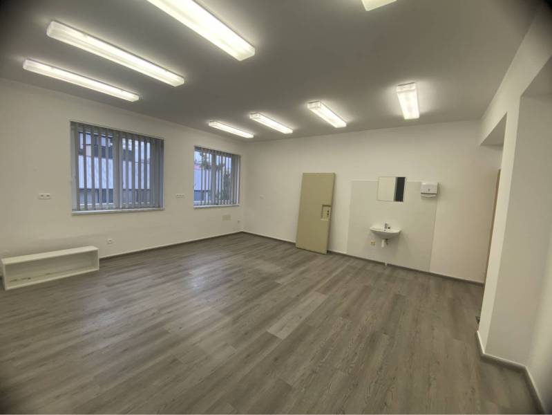 Skvelá ponuka!!! Prenájom nebytového priestoru na podnikateľské účely  - Izba v budove s podlahou s dreveným dekorom, umývadlom a žaluziami na oknách.