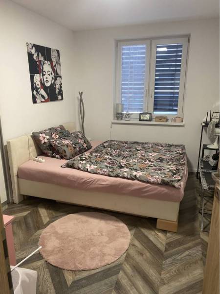 Na predaj: 3-izbový rodinný dom na predaj v obci Lesné Kračany - Spálňa v rodinnom dome s posteľou, dekoráciami a podlahou s dreveným dekorom.