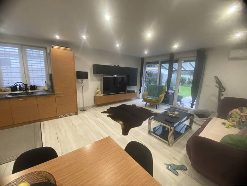 Na predaj: 3-izbový rodinný dom na predaj v obci Lesné Kračany - Obývacia izba v rodinnom dome s podlahou s dreveným dekorom, pohovkou a televízorom.