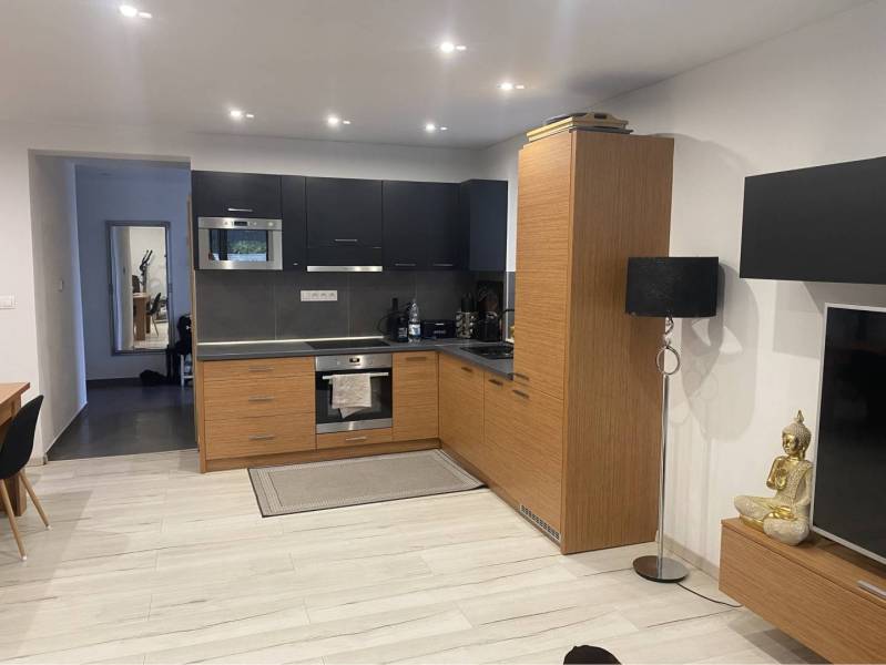 Na predaj: 3-izbový rodinný dom na predaj v obci Lesné Kračany - Kuchyňa v rodinnom dome s drevenými skrinkami a podlahou s dreveným dekorom.